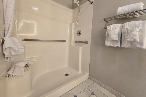 a bathroom with a shower and a bath tub with towels at OYO Hampton South Carolina Hwy 278 in Hampton-Varnville Airport