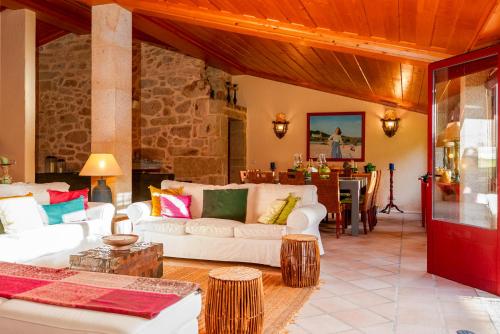 a living room with white couches and a table at Casa Justininho in Ponte de Lima