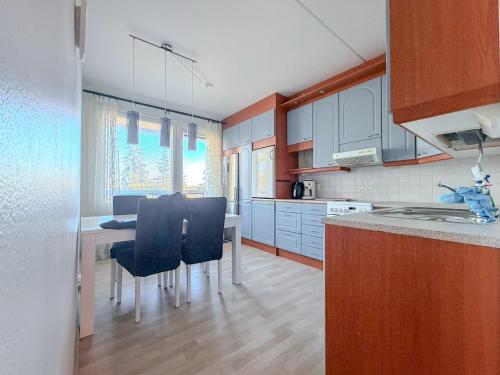 a kitchen with a table and chairs in a room at Moderni kolmio Ilmainen Pysäköinti! in Jyväskylä