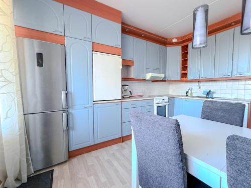 a kitchen with blue cabinets and a white refrigerator at Moderni kolmio Ilmainen Pysäköinti! in Jyväskylä