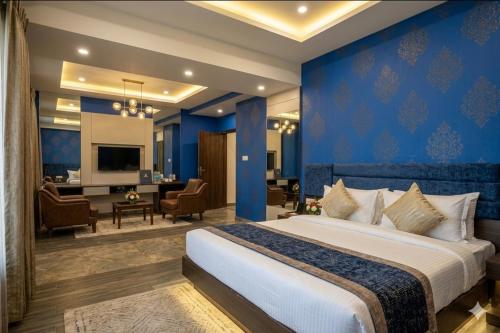 a bedroom with a large bed with a blue wall at Hotel Banana Tree & Banquets 5 Min From Anand Vihar Bus Terminal and Vaishali Metro Station in Ghaziabad