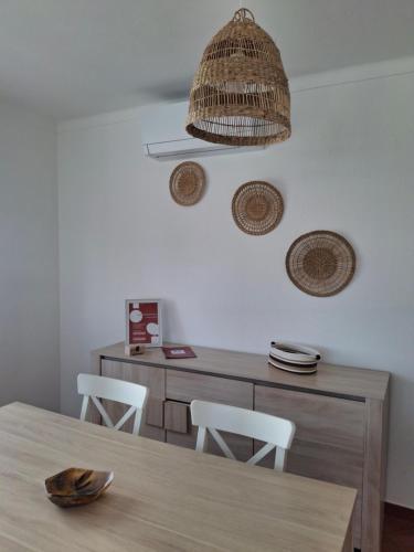 a dining room with a table with chairs and a basket at Casa R in Sesimbra