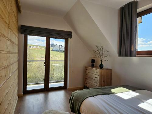 a bedroom with a bed and a large window at Apartamenty Klikuszówka in Nowy Targ