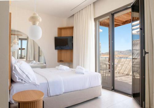 a hotel room with a bed and a balcony at Dawn Milos in Pollonia
