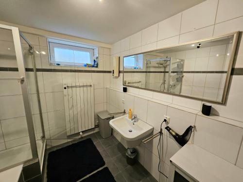 a bathroom with a sink and a toilet and a mirror at RUWERA SONNENHÜGEL - Moderne Ferienwohnung - eigener Eingang, Garten und Terrasse in Trier