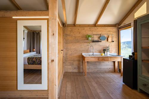 a bathroom with a sink and a bed in a room at Glamping Stregaia in Massa Marittima