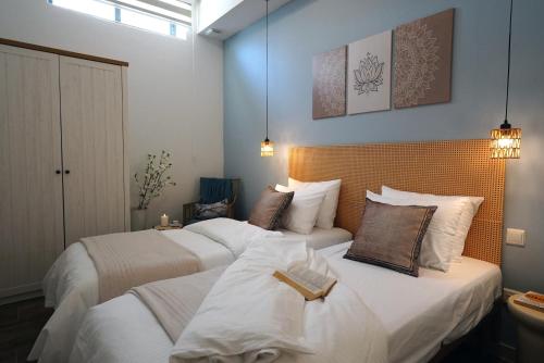 a bedroom with two beds with white sheets at Zen Loft Quiet Retreat near St julians in Is-Swieqi