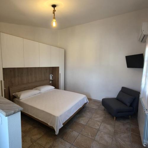 a bedroom with a bed and a blue chair at Tuscan Sunsets Tramonti Toscani in Fauglia