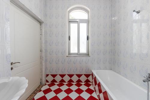 a bathroom with a red and white checkered floor at Shiroka Stays in Shirokë