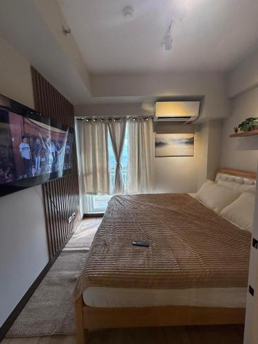 a bedroom with a large bed and a window at Verdon Parc condominium in Davao City