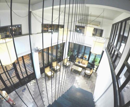 an overhead view of a building with a staircase and chairs at The August Hostel in Chiang Mai