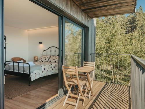 a room with a bed and a table on a balcony at Bungalows da Travanca in Arcos de Valdevez