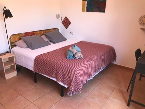 a stuffed animal is sitting on a bed at casa Maracujá in Majanicho
