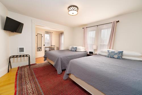 a bedroom with two beds and a flat screen tv at The Whitetail Inn and Suites- Lincoln in Lincoln