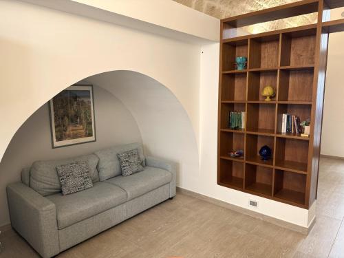 a living room with a couch and a book shelf at I quattro Pumi in Mola di Bari