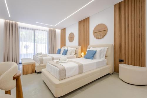 ein Hotelzimmer mit zwei Betten und einem Stuhl in der Unterkunft Crystal Blue Hotel, Barbati, Corfu in Barbati