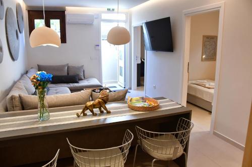 a living room with a table with chairs and a couch at Villa LEO AIGINA in Vathí