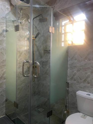 a bathroom with a glass shower with a toilet at Muniz Apartments in Lagos