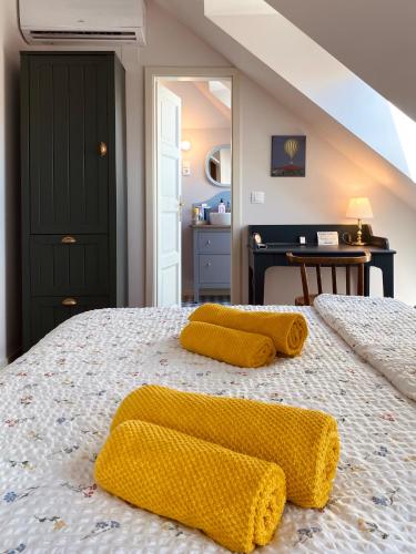 a bedroom with a bed with two yellow towels on it at Hatablak Boutique Guesthouse in Köveskál in Köveskál