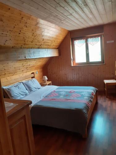 a bedroom with a bed in a wooden cabin at Chambres IM-BERG in Metzeral
