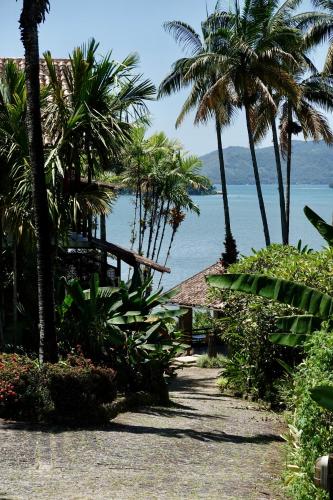 a path leading to a beach with palm trees at Santa Clara Hotel in Paraty