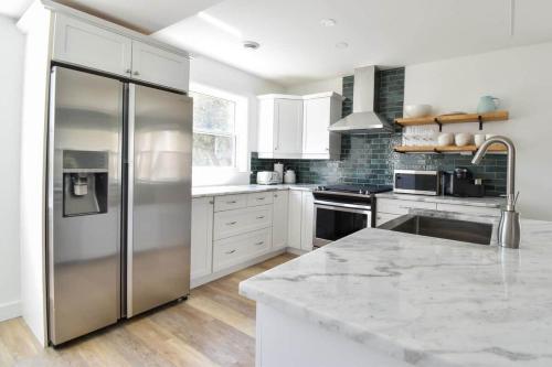 a large kitchen with a stainless steel refrigerator at The Smith - Renovated 4 Bedroom in Bloomfield