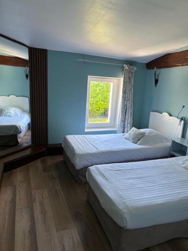 a bedroom with two beds and a window at Logis Domaine du Prieuré in Tonnay-Boutonne