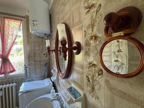 a bathroom with a sink and a mirror on the wall at Limonta, Fiori e Lago Private Apartment in Limonta