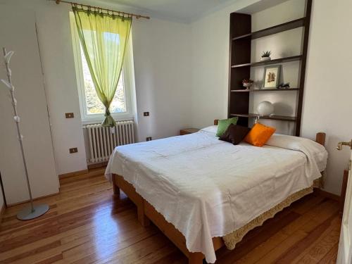 a bedroom with a large bed in a room with a window at Limonta, Fiori e Lago Private Apartment in Limonta