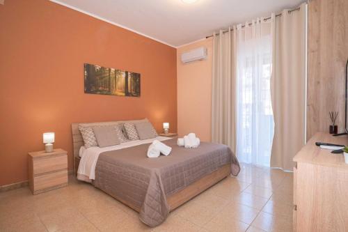 a bedroom with a bed with two towels on it at Kleos Apartment in Schisò