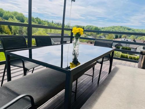 a vase of yellow flowers on a table on a balcony at Amonit 35 in Podlesice