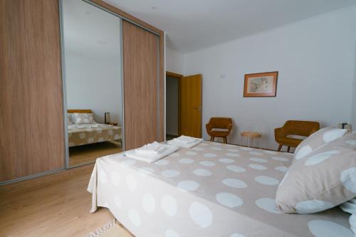 a bedroom with a large white bed and a mirror at Casas Caiado Two Houses with swimming POOL in Faro