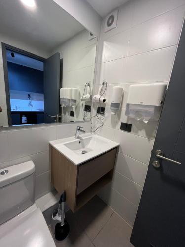 a bathroom with a sink and a toilet and a mirror at Ápice del bosque in Temuco