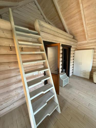 a wooden staircase in a house with a room at Verdant House in Mykulychyn