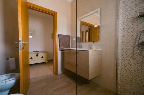 a bathroom with a sink and a toilet and a mirror at Casas Caiado Two Houses with swimming POOL in Faro