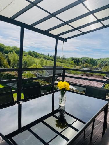 a vase of yellow flowers on a table on a balcony at Amonit 35 in Podlesice