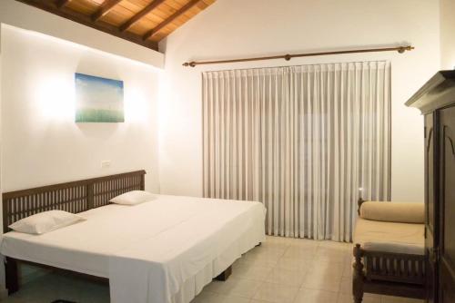a bedroom with a bed and a sliding glass door at Paradise Bay in Beruwala