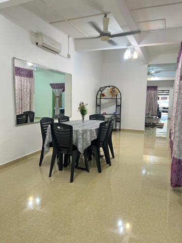 a dining room with a table and black chairs at Homestay Jerantut in Jerantut