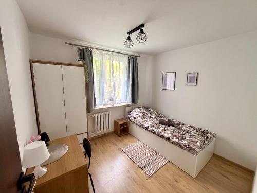 a small room with a bed and a window at Muranów Rooms Warsaw in Warsaw