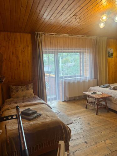 a bedroom with a bed and a large window at Садиба Близнюки in Vorokhta