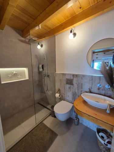 a bathroom with a sink and a toilet and a shower at Casa do Barco in Odiáxere
