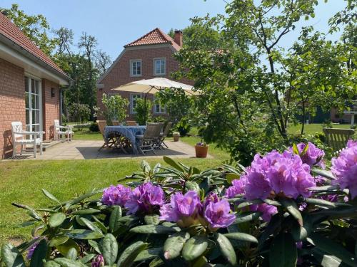 a garden with purple flowers in front of a house at Ferienhaus Bothmer in Schwarmstedt