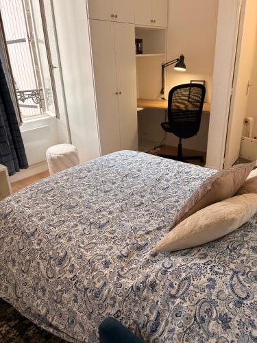 a bedroom with a bed and a desk and a chair at Studio de Dallet - Coeur de Ville in Clermont-Ferrand