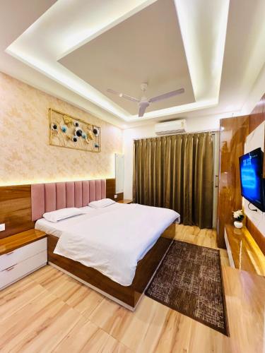a bedroom with a bed and a flat screen tv at Gr Noida Stay & BNB in Greater Noida