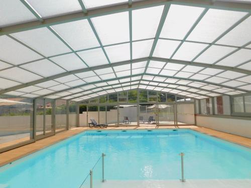 an indoor swimming pool with a glass ceiling at Chalet HABIA TXIKIA 4 pers, neuf, sur Hasparren, calme, avec piscine et climatisation, Pays Basque in Hasparren