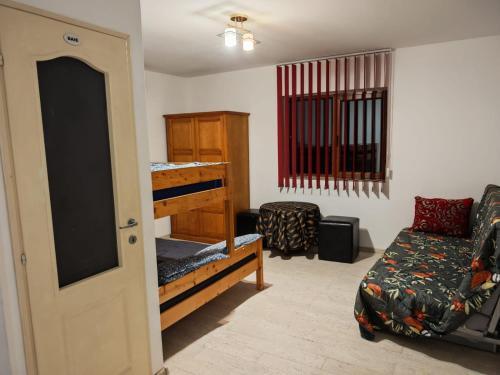 a room with a bed and a couch and a chair at Pensiunea Solo in Dretea