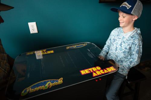 a young boy is standing next to a table with a skateboard at The Speckled Trout Outpost in Damascus