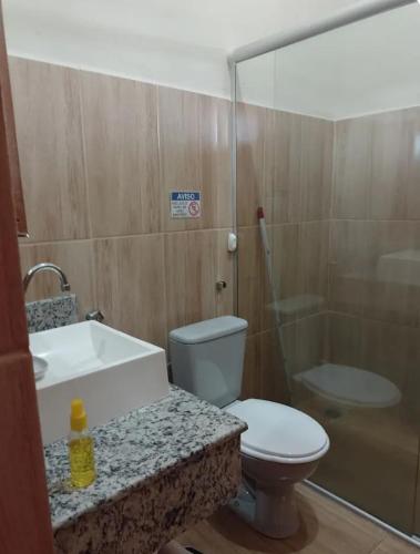 a bathroom with a toilet and a sink and a shower at Rancho Macalé Balneário de Rancharia Sp in Rancharia