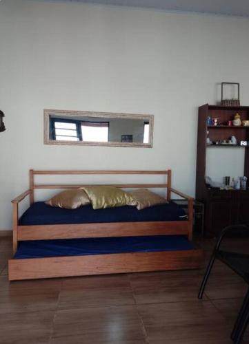 a bedroom with a wooden bed with a mirror at Rancho Macalé Balneário de Rancharia Sp in Rancharia