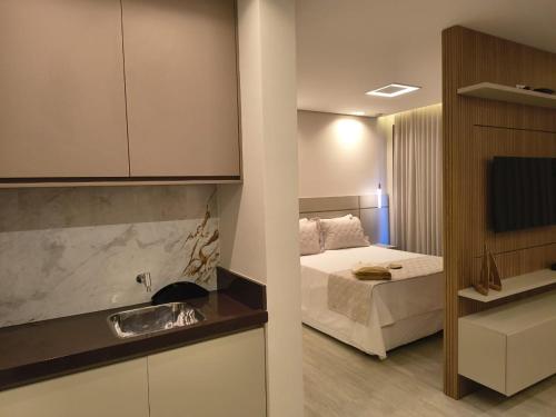 a bedroom with a bed and a kitchen with a sink at Píer 135 Escarpas in Capitólio
